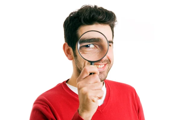 Curious young man looking through magnifying glass, isolated on white — Stock Photo, Image