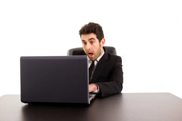 与工作的年轻商业男子是在办公桌，被隔绝在白色的笔记本电脑 — 图库照片