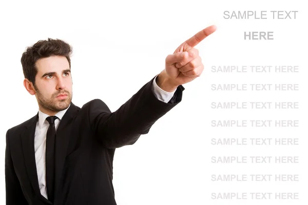 Young business man pointing at something interesting on a white background — Stock Photo, Image