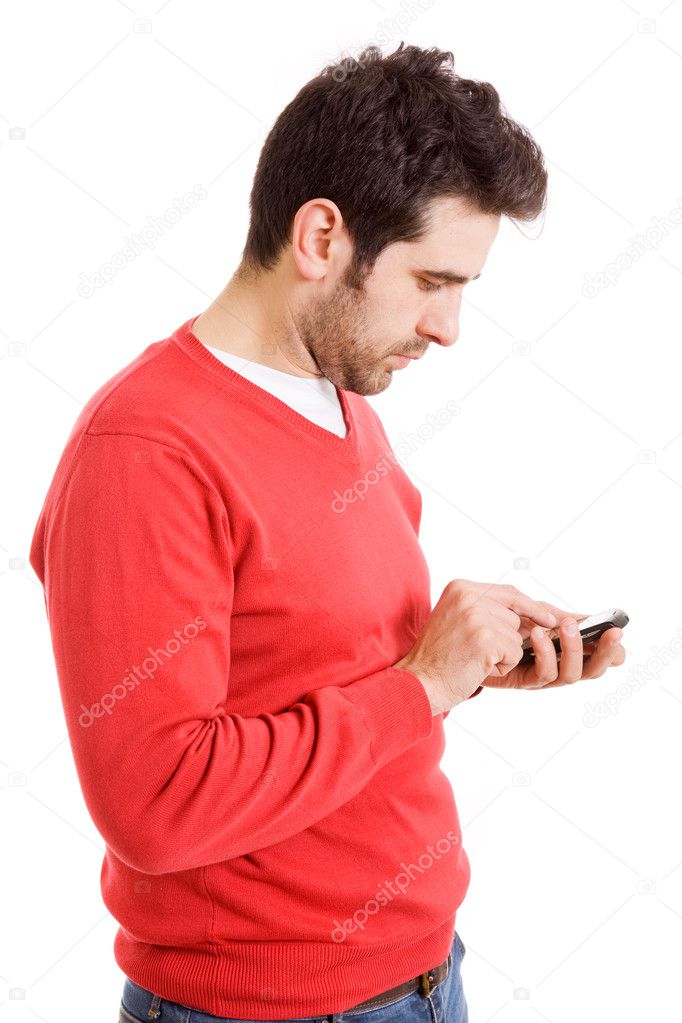 Portrait of a young boy text messaging on mobile phone against white background