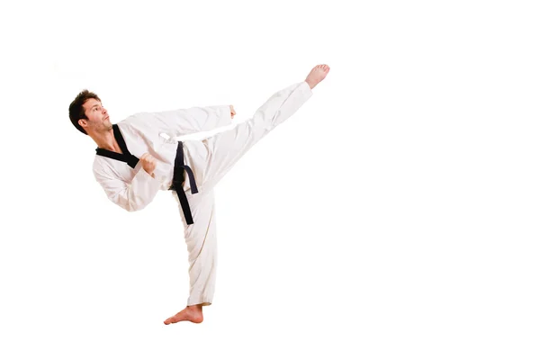 Young man practicing martial arts over white background — Stock Photo, Image