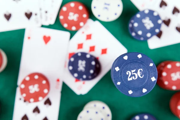 Fichas de póquer y cartas en un fieltro verde — Foto de Stock