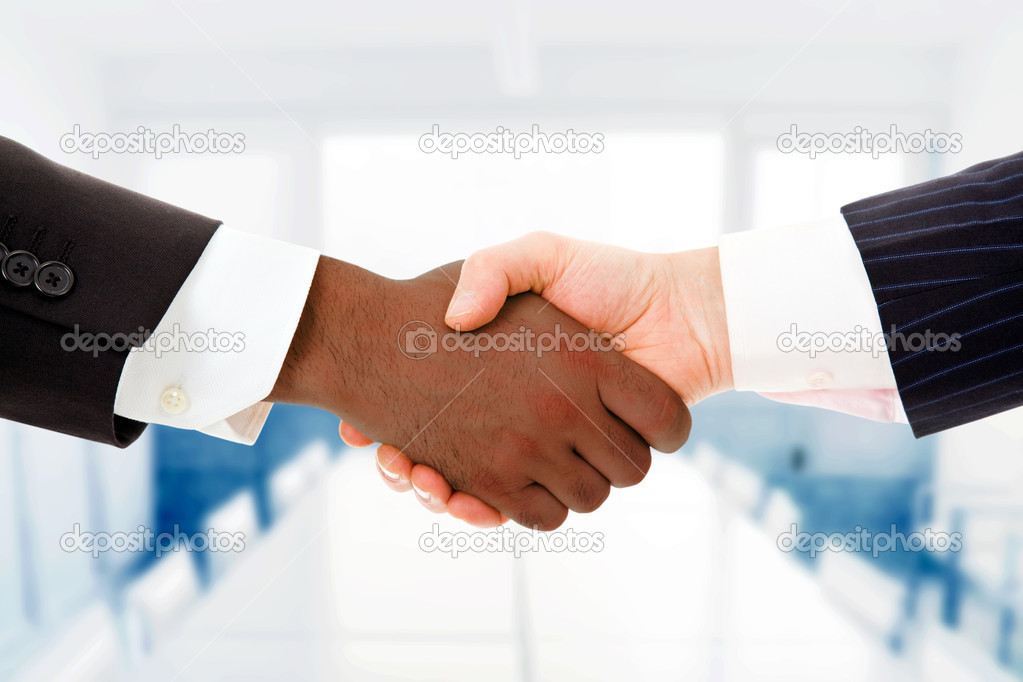 Closeup of a multiracial handshake between two business men at t