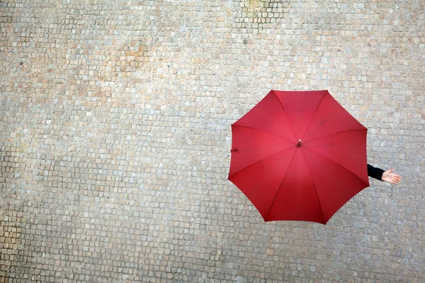 Деловая женщина, спрятанная под зонтиком и проверяющая, идет ли дождь — стоковое фото