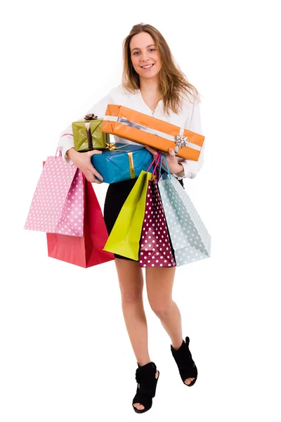 Shopaholic joven mujer sosteniendo regalos y disparando bolsas en blanco —  Fotos de Stock