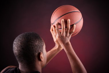Siyah arka planda genç erkek basketbolcu