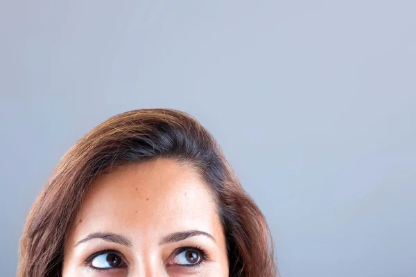 Closeup portret van een jonge vrouw opzoeken op grijze achtergrond — Stockfoto