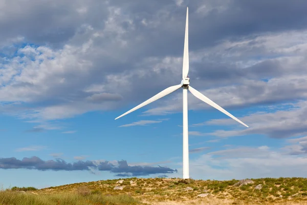 White wind turbine in the top of the mountain generating electri — Stock Photo, Image