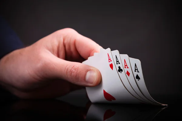 Four aces in the hand on black background — Stock Photo, Image