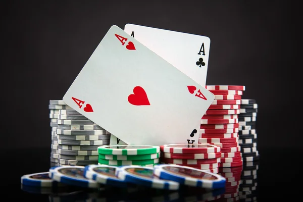 Fichas de póquer y cartas sobre fondo negro — Foto de Stock