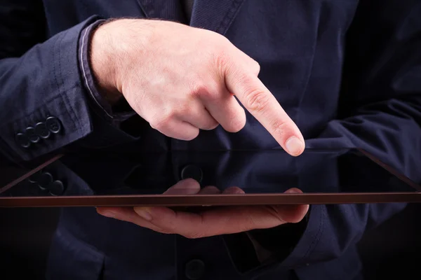 Man holding a digital tablet on black background — Stock Photo, Image