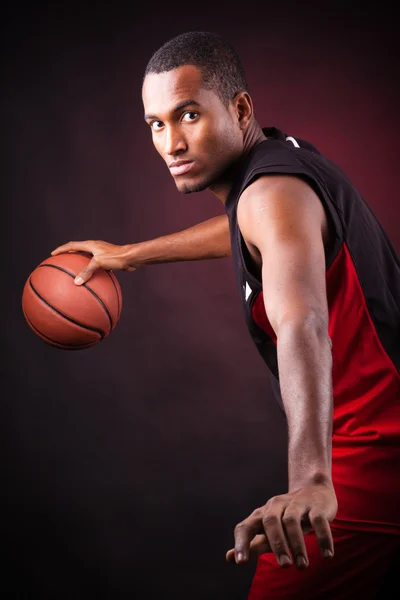 Portrait of a young male basketball player against black backgr — Stock Photo, Image