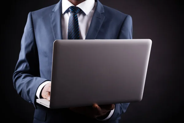 Negócios homem negro whit laptop no fundo preto — Fotografia de Stock