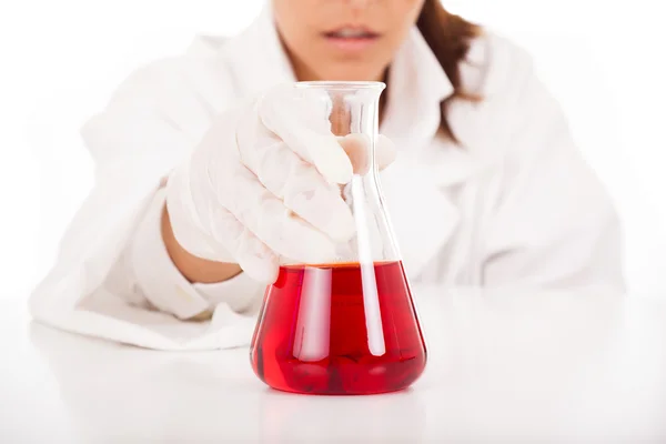 Kvinnliga forskare kontroll en kolv med vätska, isolerad på vit — Stockfoto