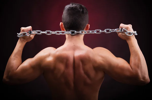 Muscular young man from back on black background — Stock Photo, Image