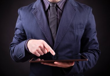Dijital tablet siyah arka planda tutan adam