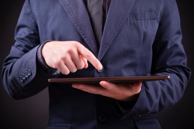 Dijital tablet siyah arka planda tutan bir adam closeup