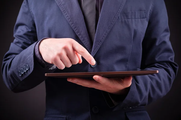 Primo piano di un uomo che tiene un tablet digitale su sfondo nero — Foto Stock