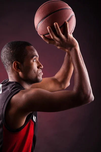 Πορτρέτο του ένα νεαρό αρσενικό μπασκετμπολίστας ενάντια μαύρο έκφραση — Φωτογραφία Αρχείου