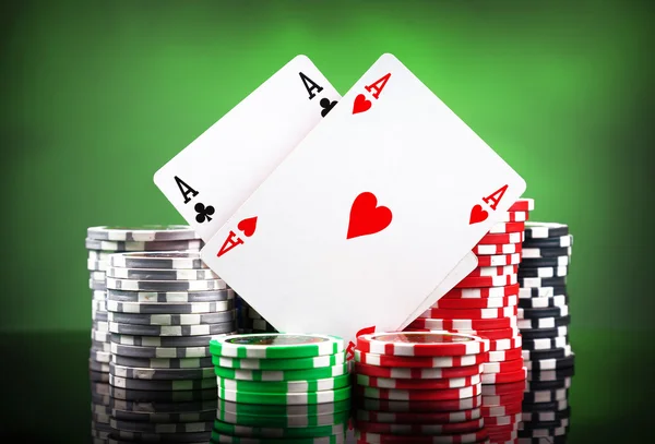 Fichas de póquer y cartas sobre fondo verde — Foto de Stock