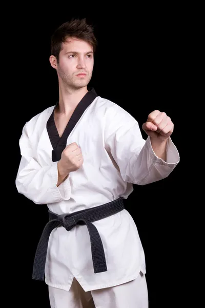 Jonge man beoefenen martial arts op zwarte achtergrond — Stockfoto