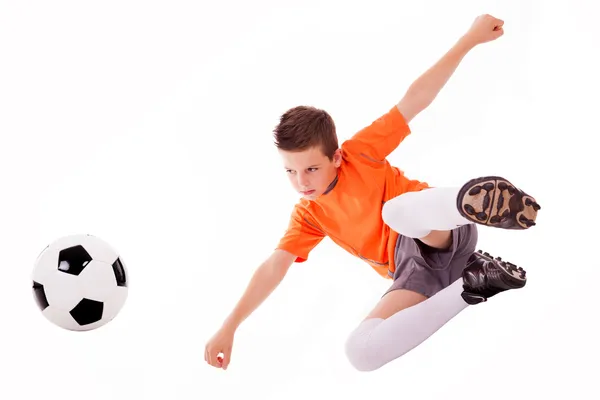 Chlapec dělat akrobatické kop s fotbalovým míčem, izolované na bílém Stock Snímky