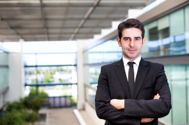 modern ofisindeki bir gülümseyen genç işadamı portresi