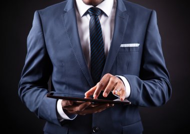 siyah adam karşı dijital tablet üzerinde çalışan iş adamı
