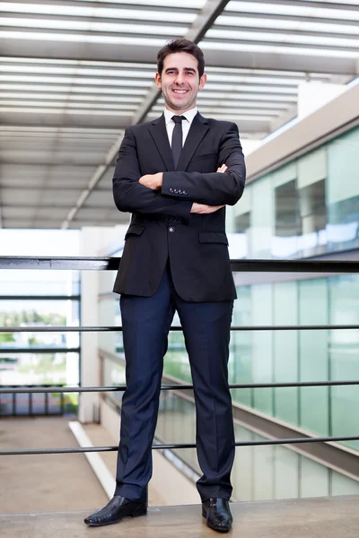Portret van een glimlachende jonge zakenman op moderne kantoor — Stockfoto