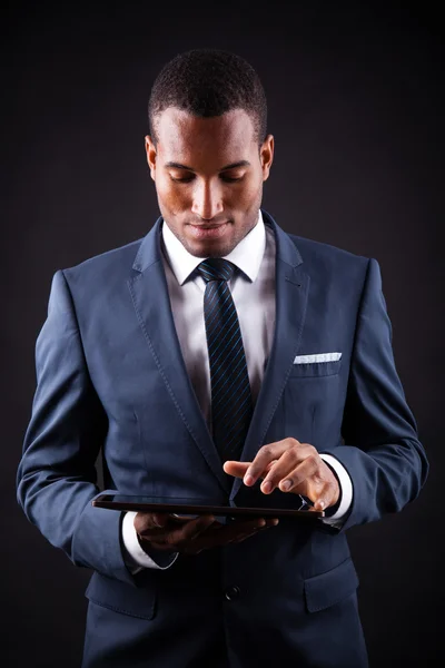 Young business man with a digital tablet on black background — Stock Photo, Image