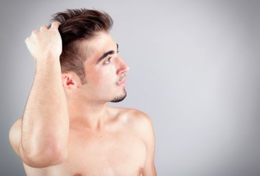 yakışıklı bir genç adam, gri bir arka plan üzerinde portresi