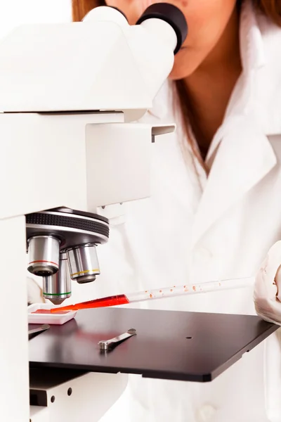 Closeup of a female scientist looking through microscope, isolat — Stock Photo, Image