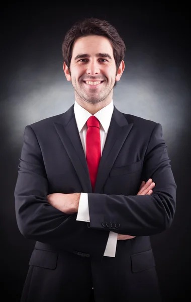 Friendly handsome businessman standing on black background — Stock Photo, Image