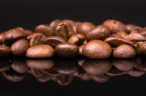 Купа кавових зерен на чорному тлі — стокове фото