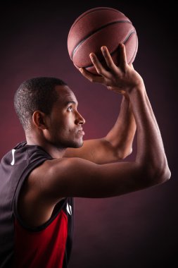 Siyah arka planda genç erkek basketbolcu