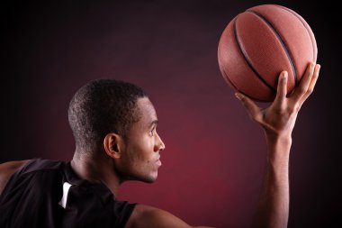 Siyah arka planda genç erkek basketbolcu
