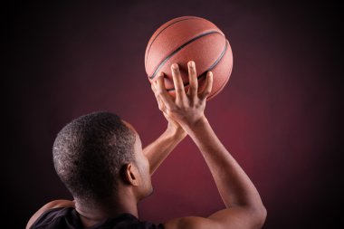 Siyah arka planda genç erkek basketbolcu