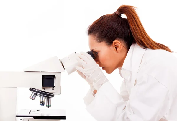 Female researcher looking through microscope, isolated on white — Stock Photo, Image