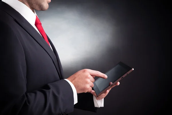 Business man working with a tablet computer on black background — Stock Photo, Image