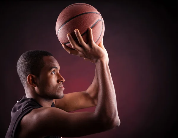 Portret van een jonge mannelijke basketbalspeler tegen zwarte backgr — Stockfoto