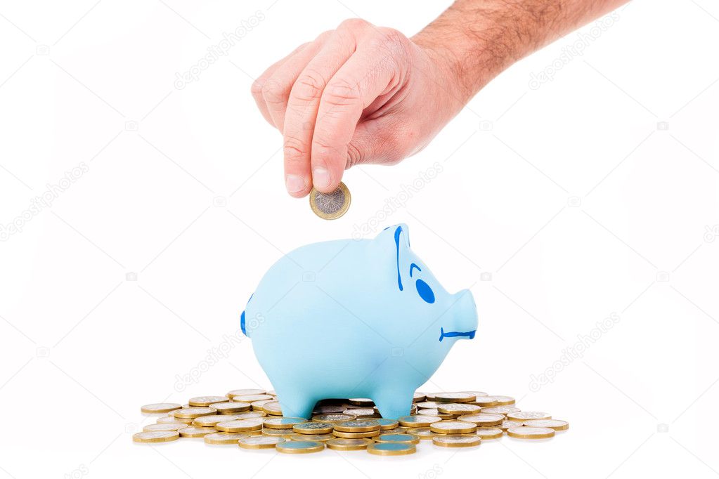 Hand insert coin into the piggy bank, isolated on white