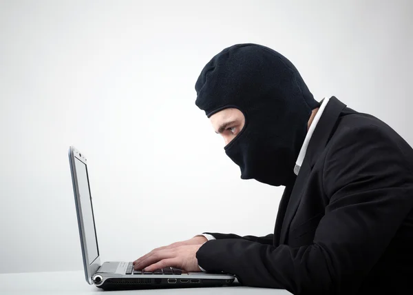 Hacker stehlen Informationen von einem Computer am Schreibtisch — Stockfoto