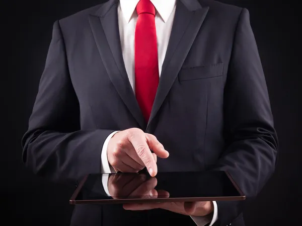 Homem segurando tablet digital contra fundo preto — Fotografia de Stock