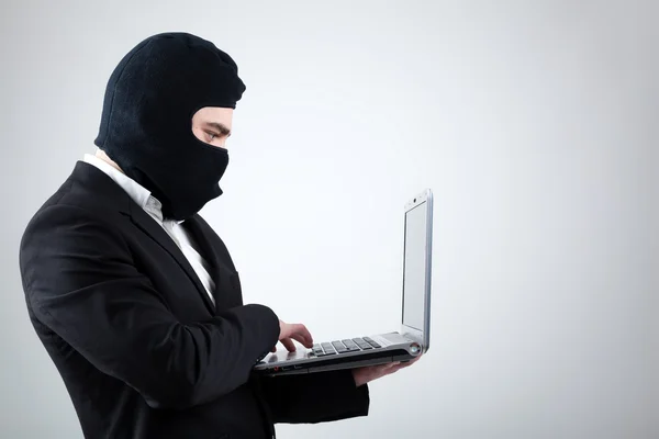 Хакер крадет информацию с ноутбука — стоковое фото