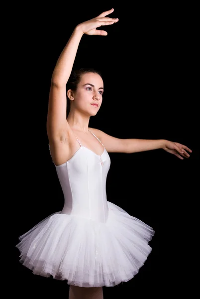 Teenie-Balletttänzerin steht in einem Tutu auf schwarzem Hintergrund — Stockfoto