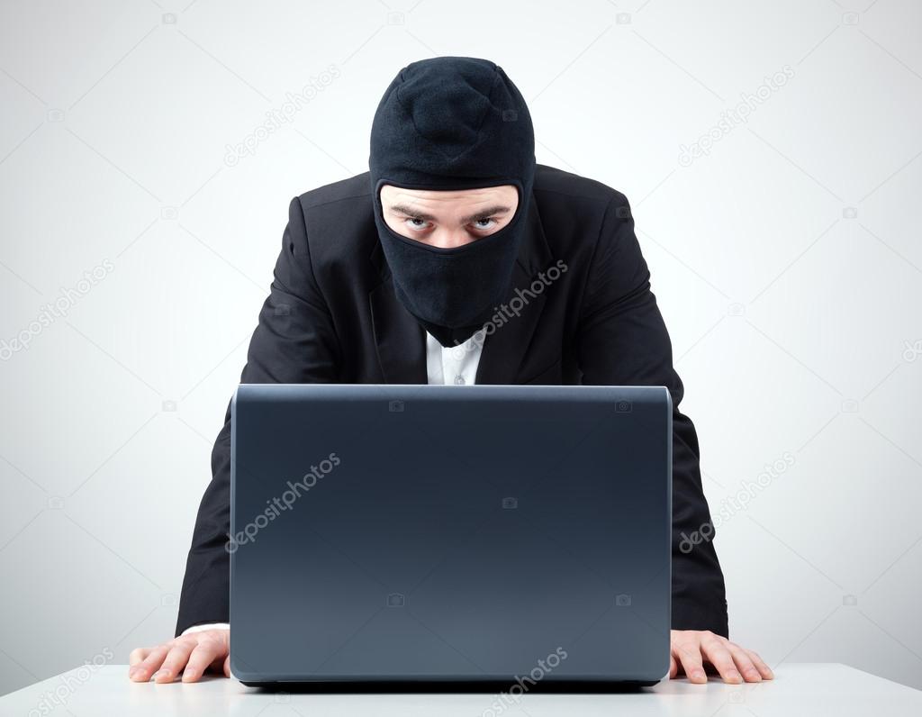 Hacker stealing information from a computer at the desk