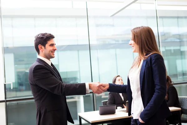 Geschäftlicher Händedruck im modernen Büro mit Geschäftigkeit auf bac — Stockfoto