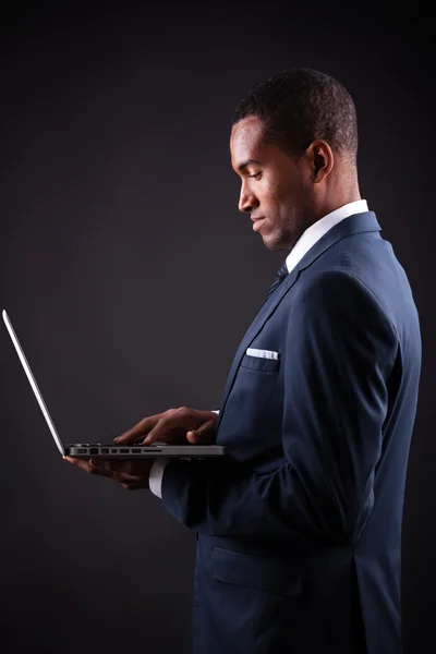 Business svart man whit laptop på svart bakgrund — Stockfoto