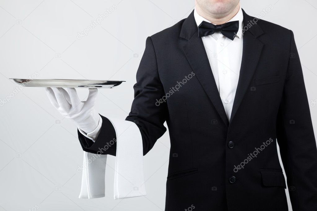 Waiter holding empty silver tray over gray background