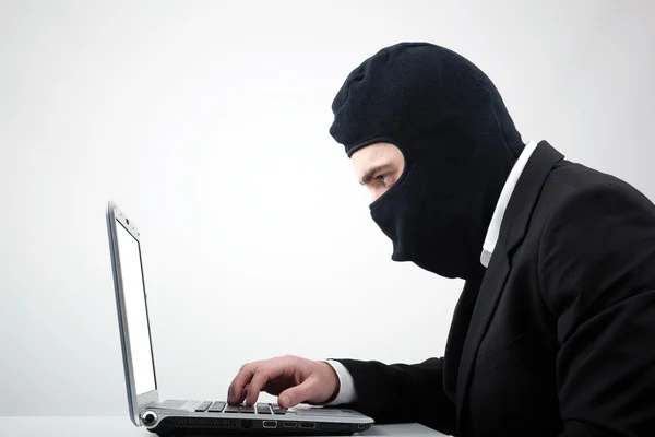 Retrato de um hacker com balaclava contra fundo cinza — Fotografia de Stock